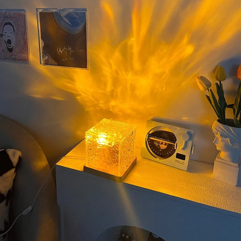 LED water ripple projection night light with remote control on wooden surface