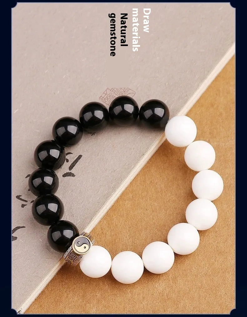 Black and white obsidian Taiji mantra bracelet with geometric beads and yin-yang symbol.