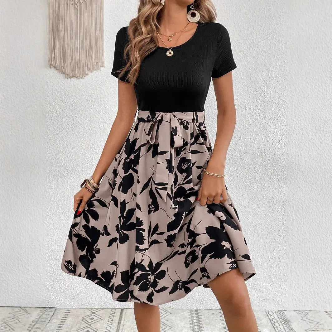 A khaki-coloured A-line women's dress with a floral print, showing regular sleeves and shoulder strap details.