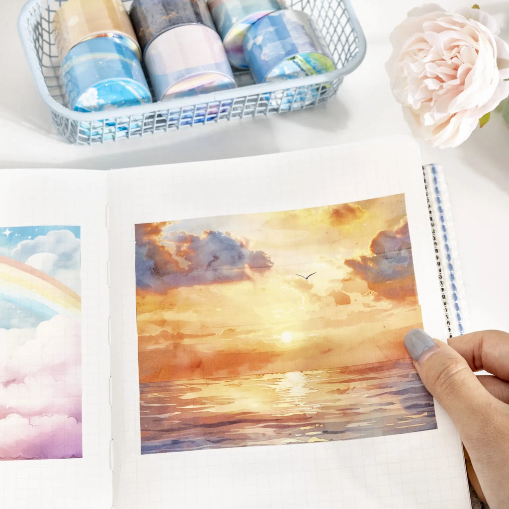 Japanese paper washi tape roll with sky theme designs including clouds, sun, moon, and nebula patterns