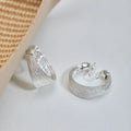 Set of four geometric earring pairs in silver and gold, including stud and clip styles