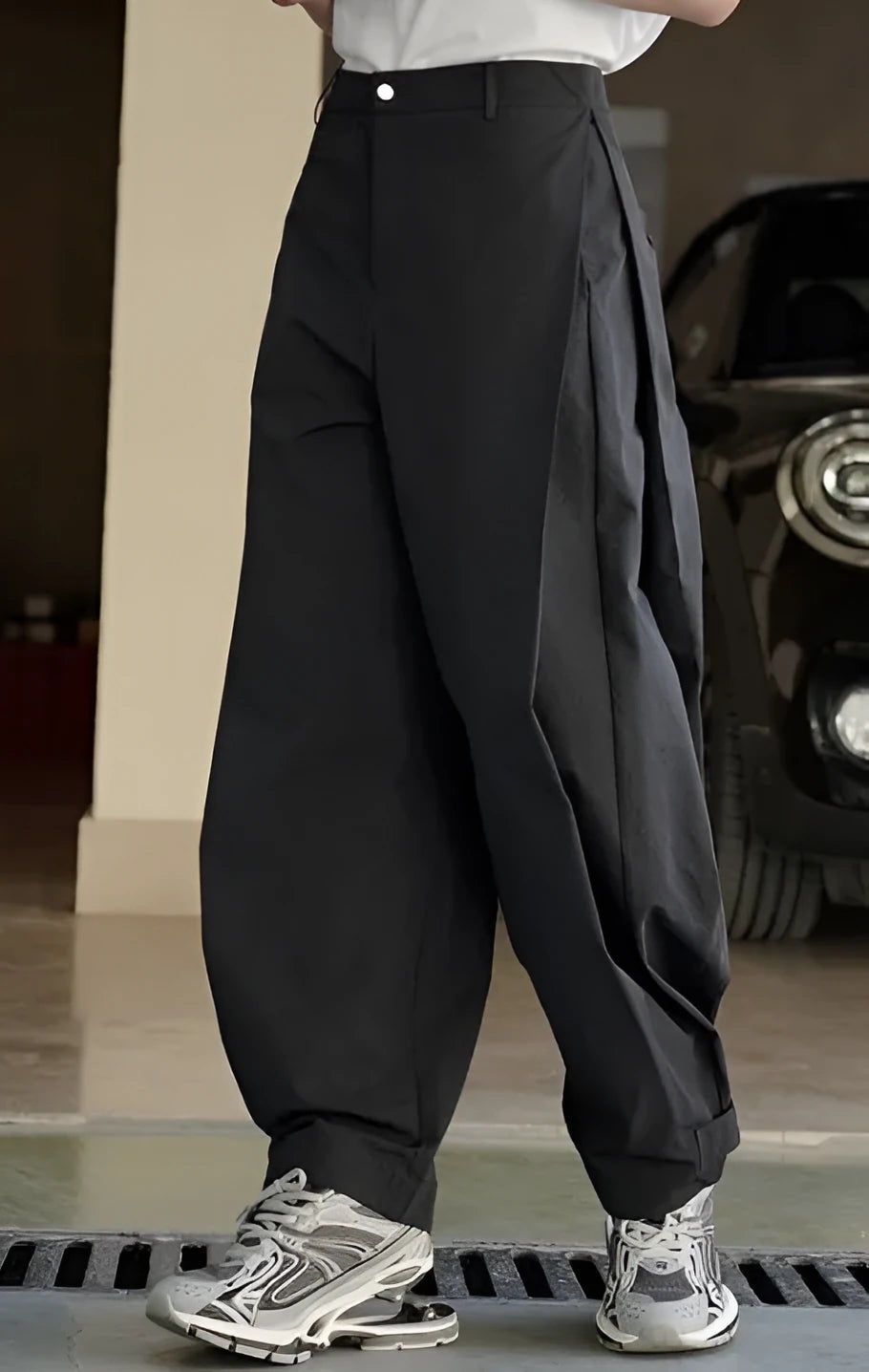 Black high-waisted pleated wide-leg casual trousers with an elasticated waistband laid flat.