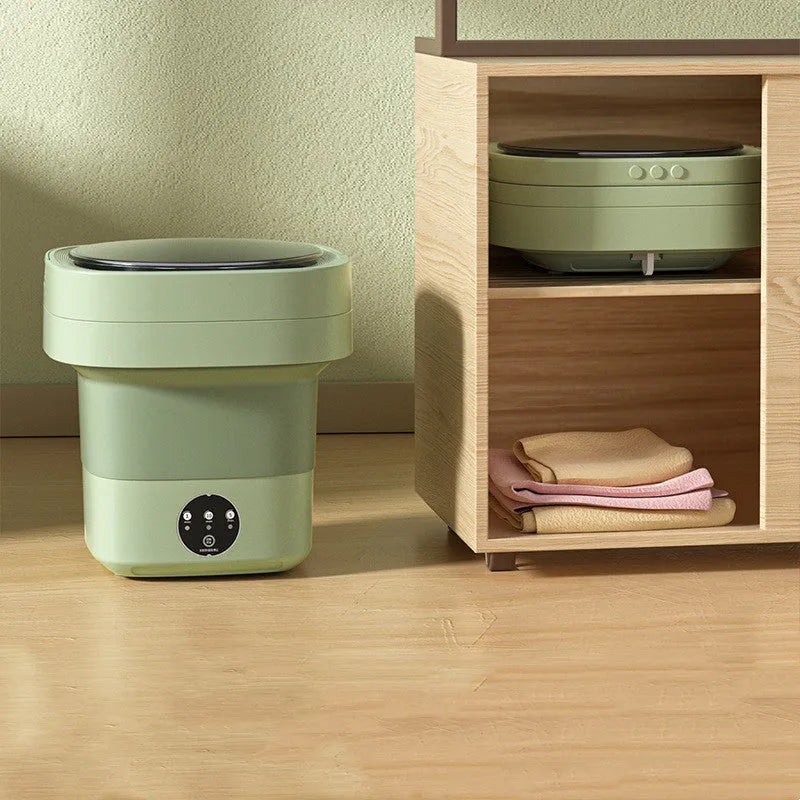Green foldable mini portable washing machine with drain pipe and basket on a white background.