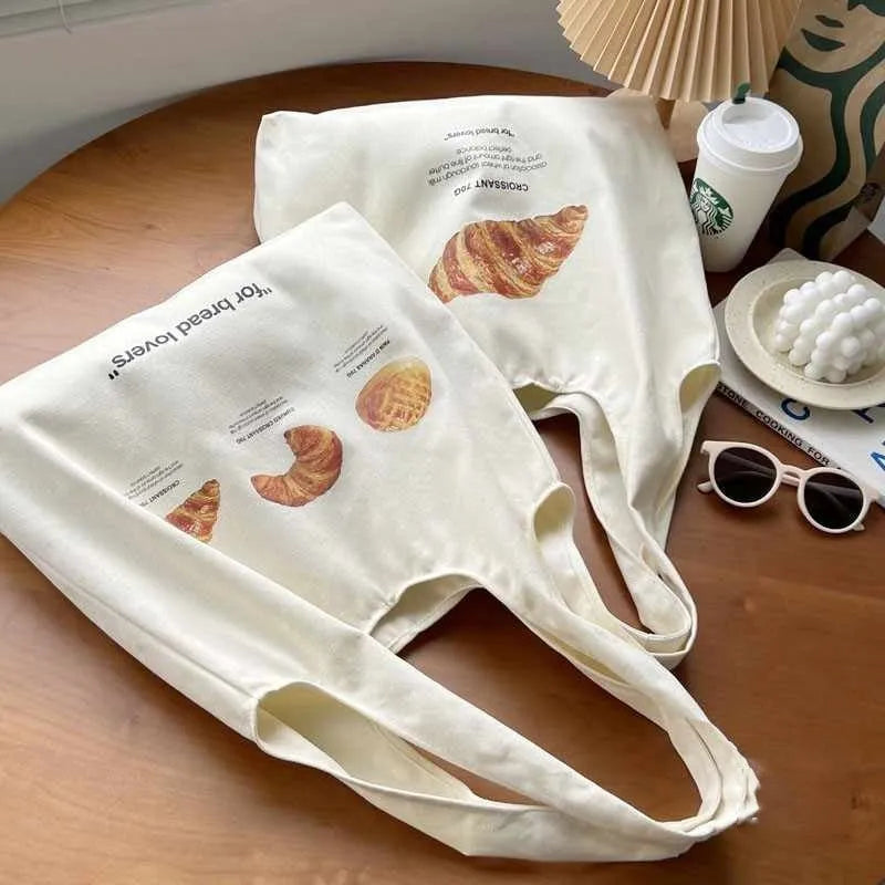 Beige canvas shoulder bag with bread design showing front width and shoulder strap