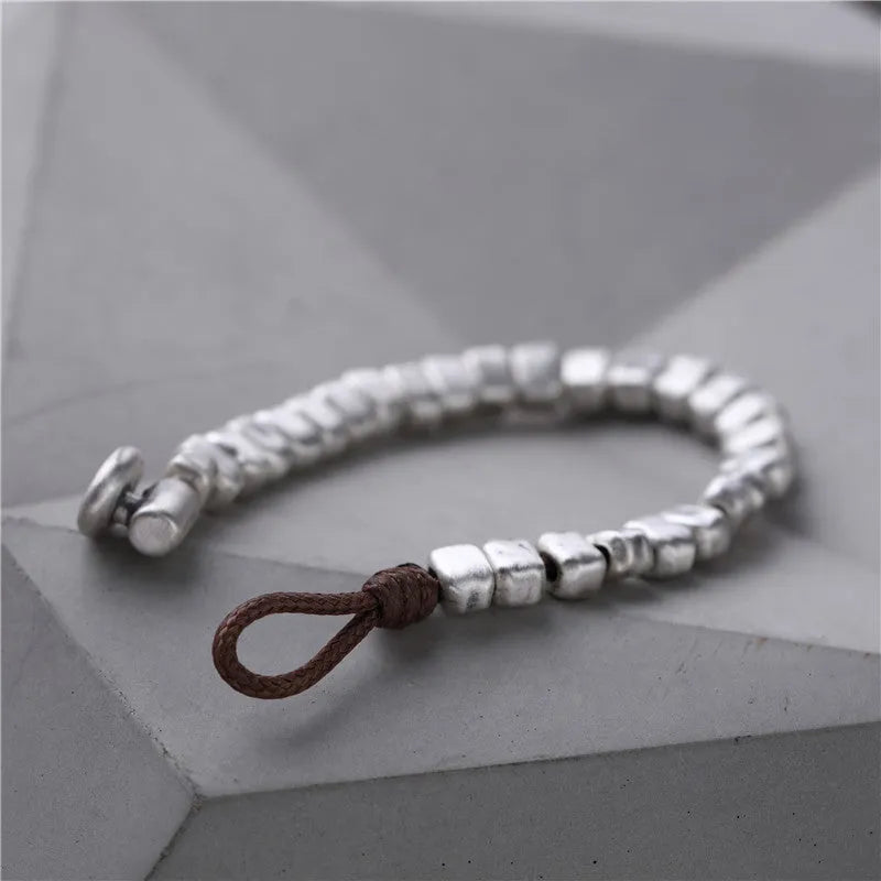 Women's handmade bracelet with irregular silver squares and wooden accents on elastic band