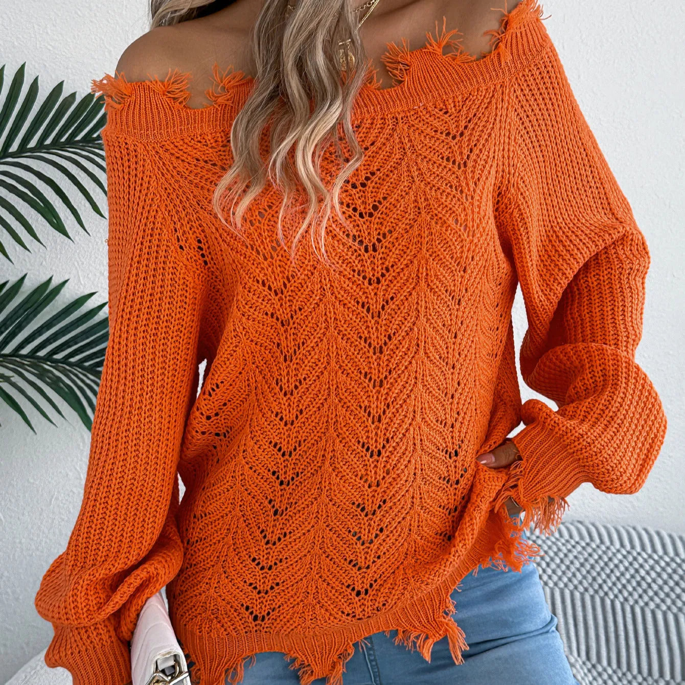 White cut-off shoulder pullover sweater with hollow-out detailing and long sleeves.