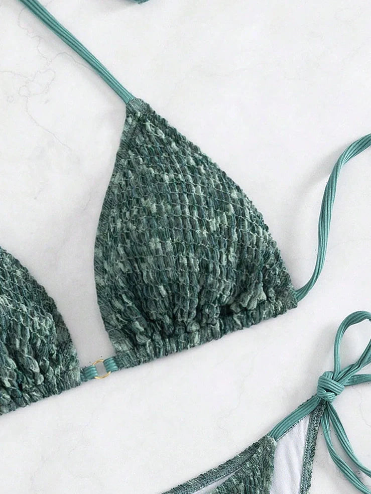 Green backless halter swimsuit with adjustable straps and matching shorts on mannequin