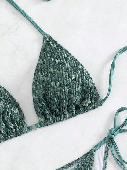 Green backless halter swimsuit with adjustable straps and matching shorts on mannequin