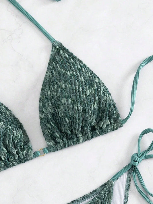 Green backless halter swimsuit with adjustable straps and matching shorts on mannequin