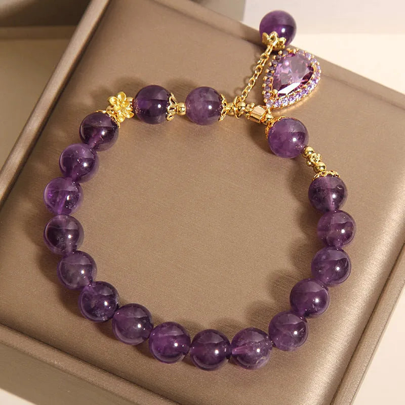 Natural amethyst bracelet with gold-plated inlay and purple droplet pendant on white background