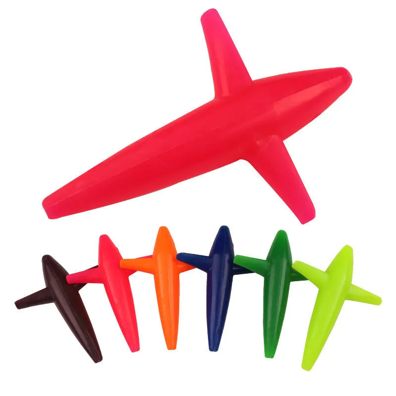 Multi-colour aircraft sea fishing lure in blue, green, and purple on a sandy beach