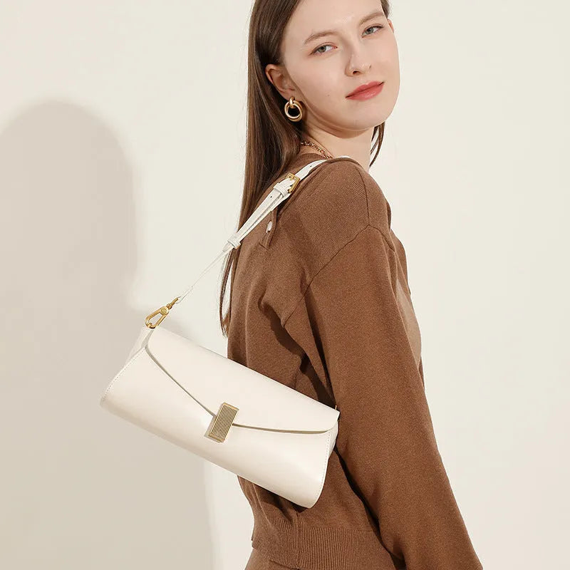 Women's cowhide leather cross-body bag in pillow shape with clamshell opening, shown in milky white colour