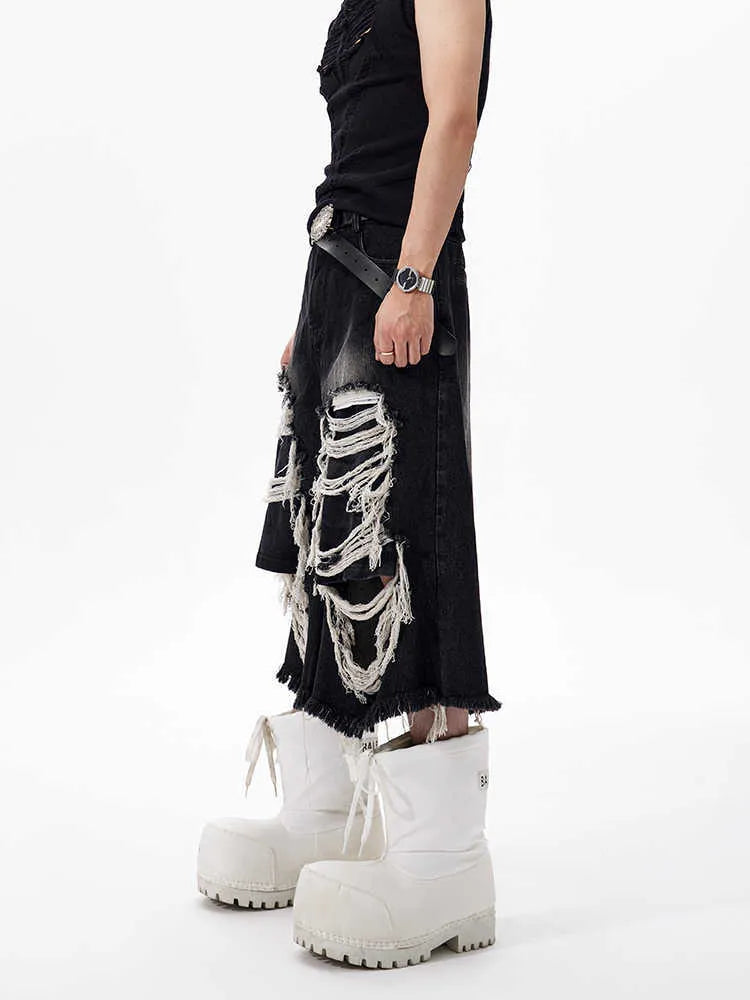 Black wide-leg cropped jeans with a ripped patch detail on the leg, showing a mid-high waist and loose fit.