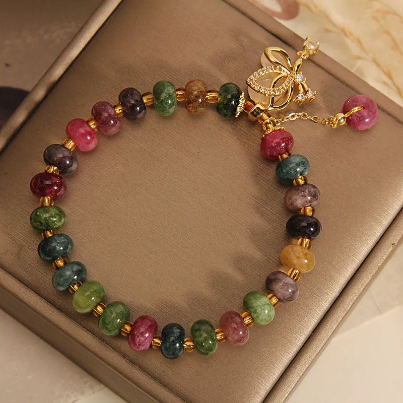 Colourful alloy bracelet for women with a butterfly charm and tourmaline beads on a fresh sweet style band.