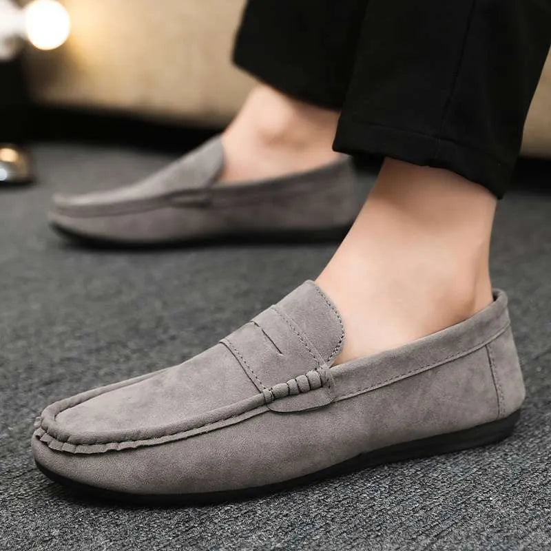 Men's black Gommino Korean fashion slip-on shoes with round toe and textured grape particle detailing on the PU upper.