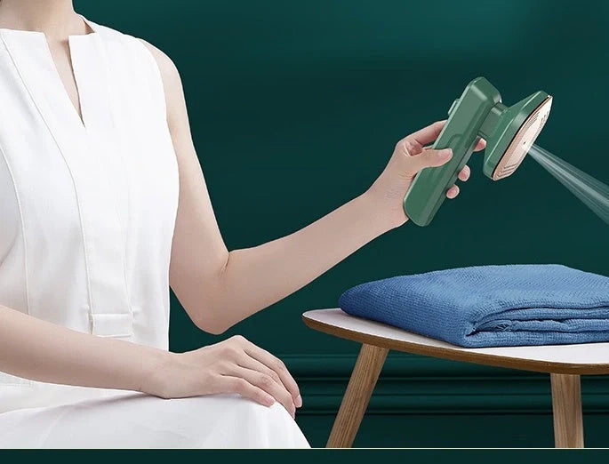 Green handheld garment steamer for quick ironing and sterilisation