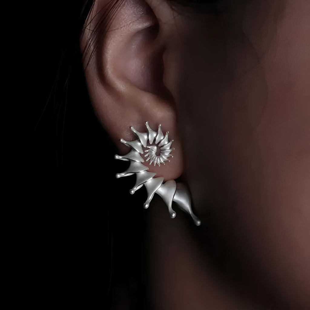 A pair of matte finish conch stud earrings with a three-dimensional, irregular alloy design.