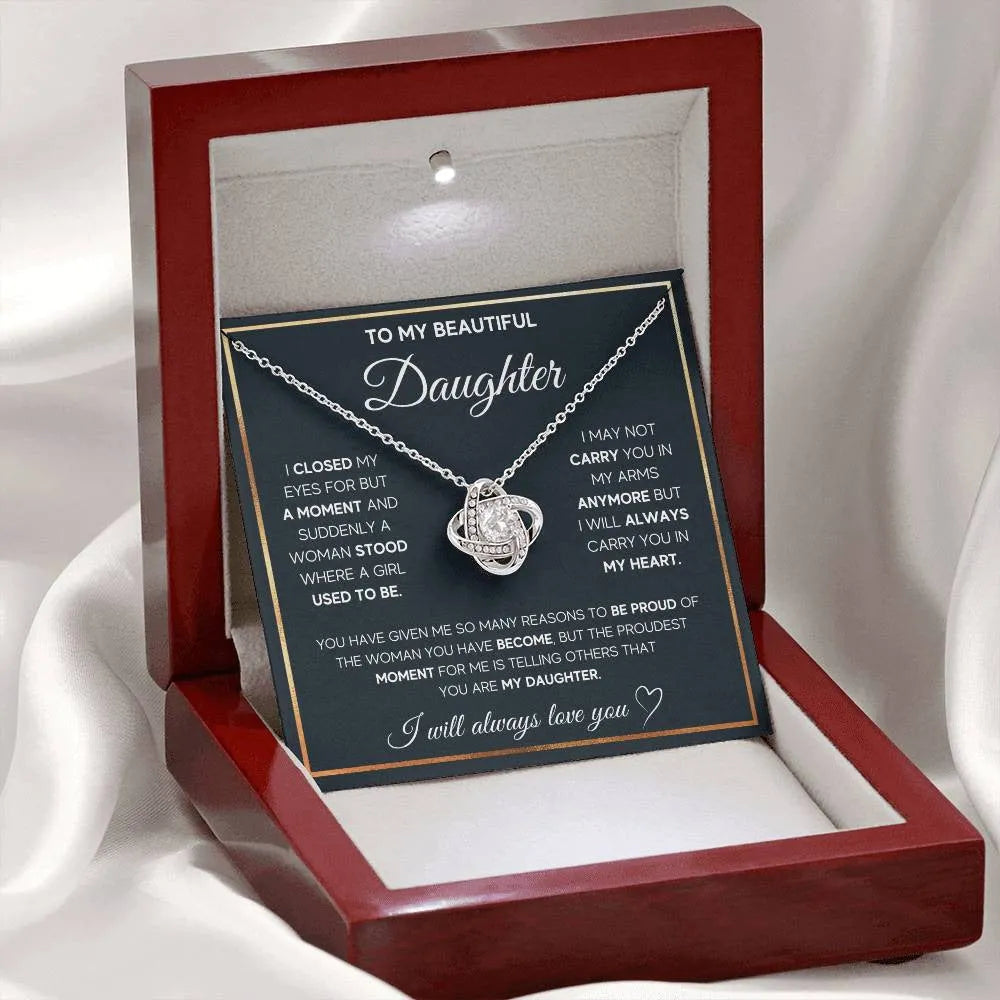 Silver metal four-leaf clover hollow jeweled pendant clavicle chain on display with geometric shape and card beside flip gift box