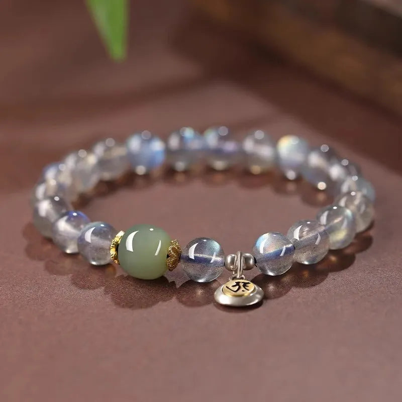 Close-up of an 8mm Moonstone crystal bracelet showing a detailed Thousand-Hand Kwan-yin mouse design.