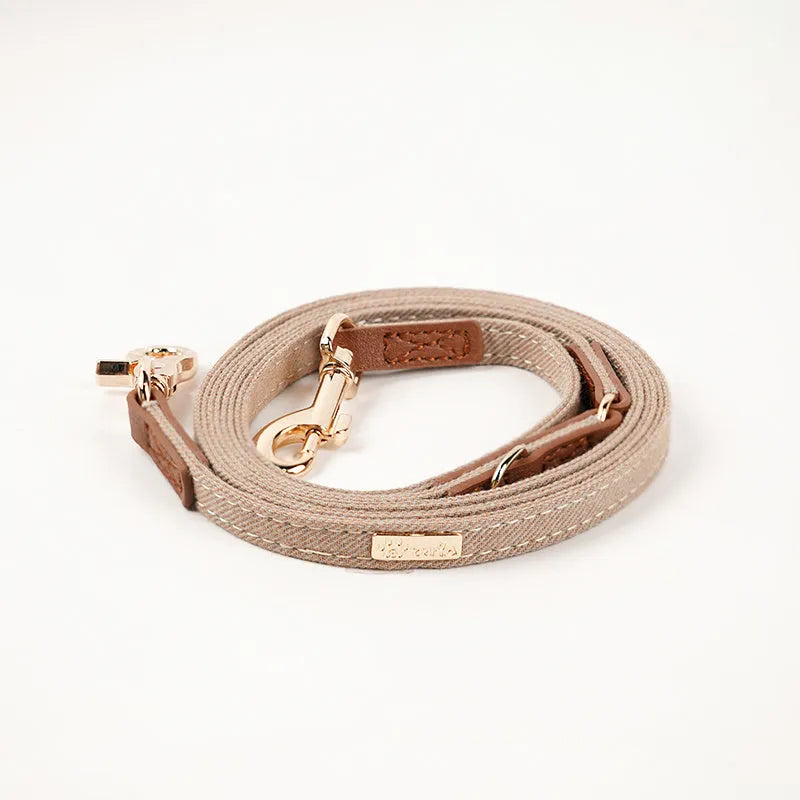 Adjustable mohair dog collar with nameplate and hand holding rope in cement gray