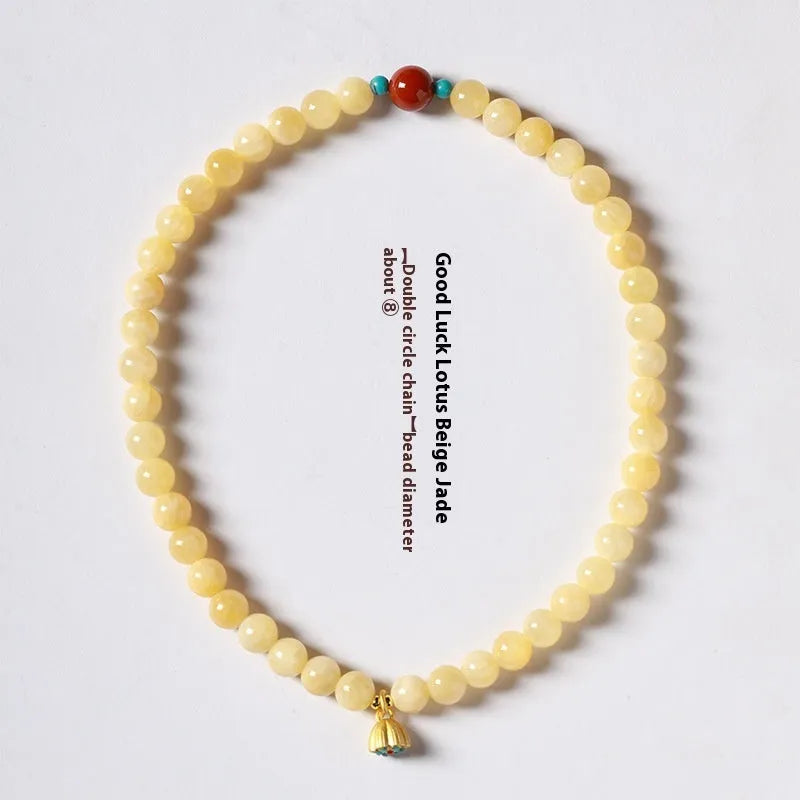 Yellow jade double ring bracelet with topaz lotus seedpod design on white background