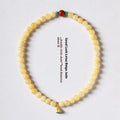 Yellow jade double ring bracelet with topaz lotus seedpod design on white background
