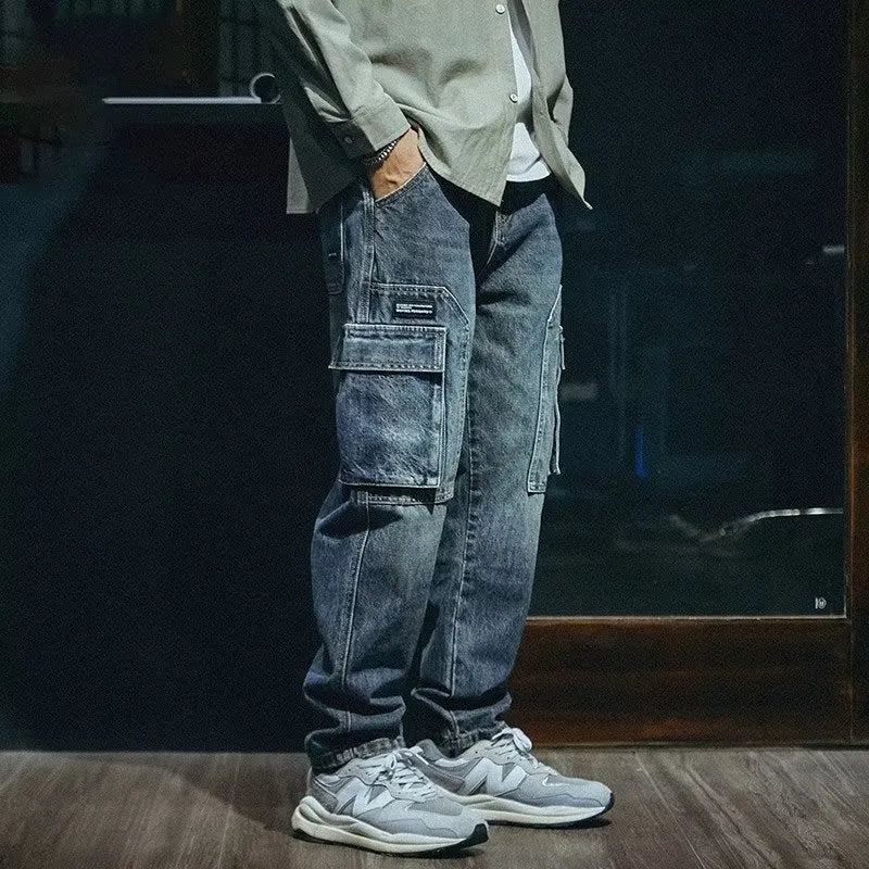 Men's blue loose straight leg jeans with a zip fly on a plain background.