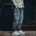 Men's blue loose straight leg jeans with a zip fly on a plain background.