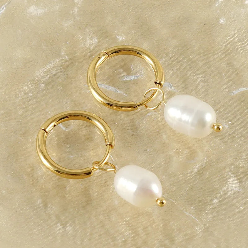 A pair of gold geometric earrings with pearl details on stainless steel and titanium steel posts.