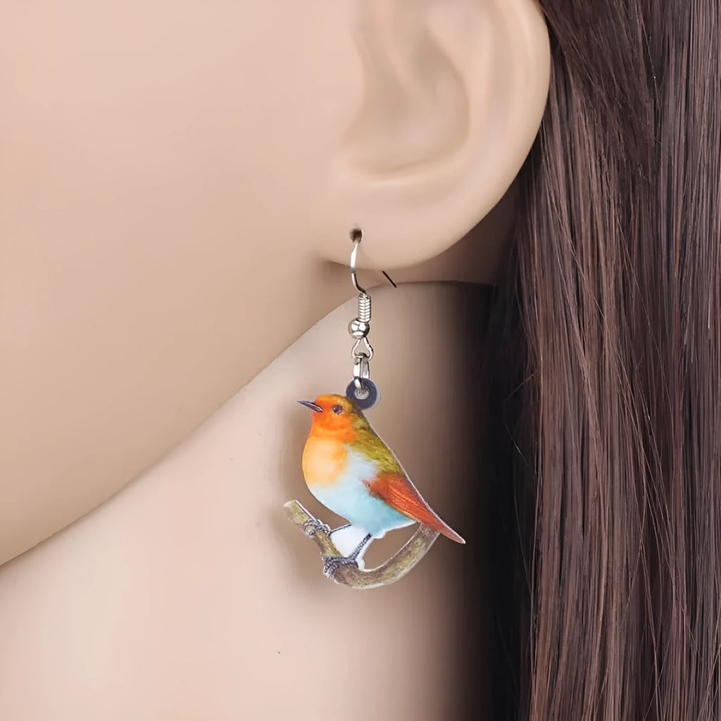 Blue titmouse bird design acrylic pendant earrings with geometric and snake detailing.