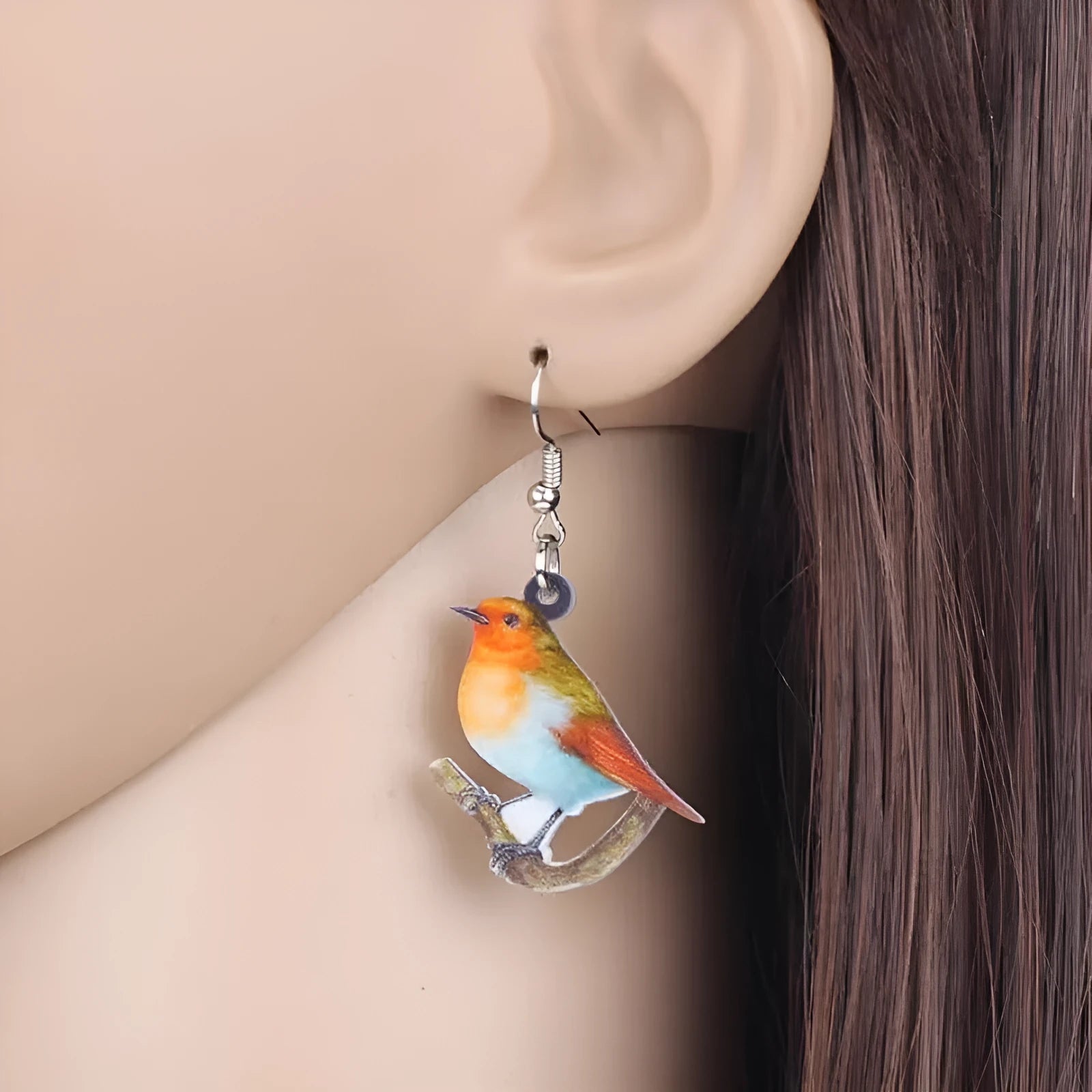 Blue titmouse bird design acrylic pendant earrings with geometric and snake detailing.