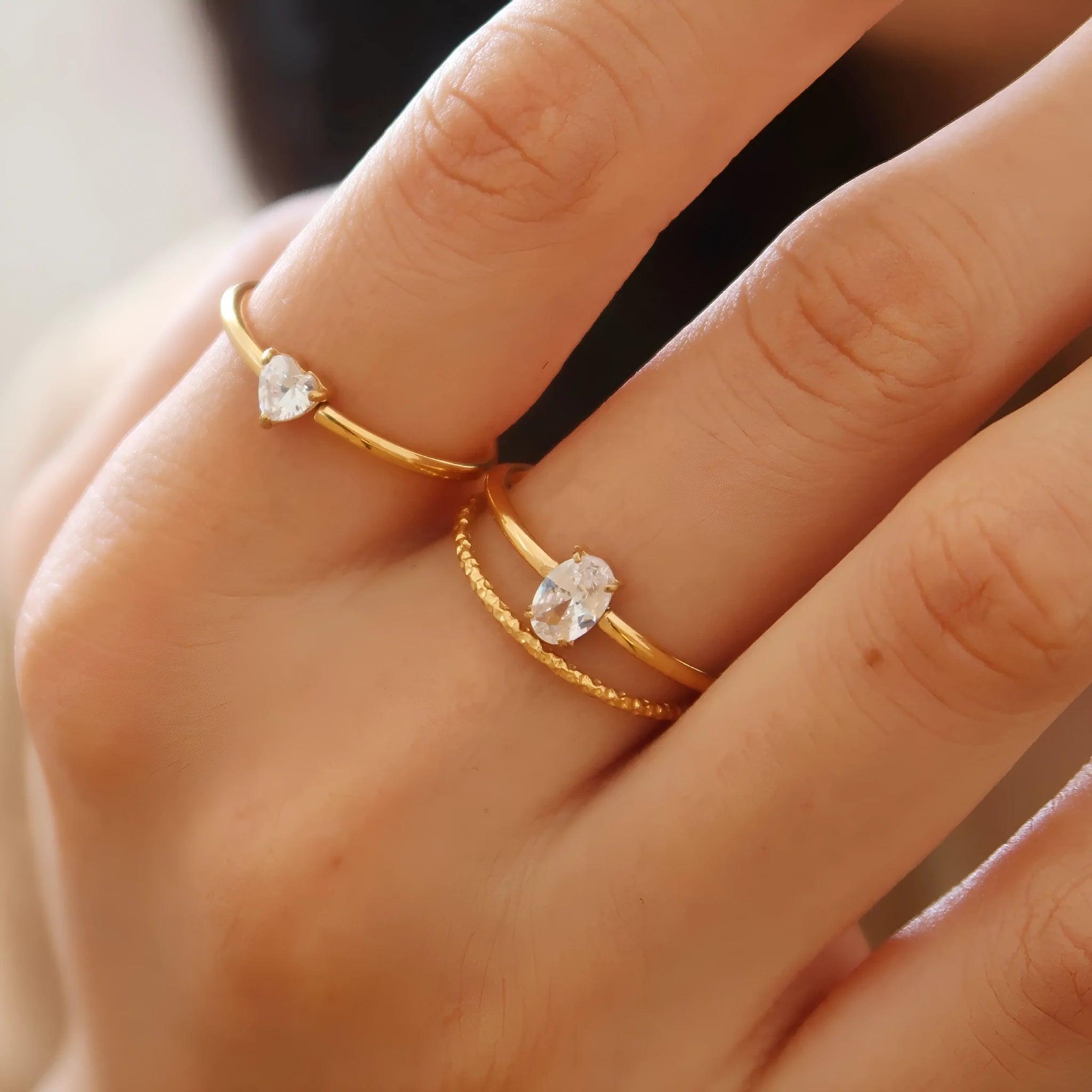 Women's golden electroplated stainless steel ring showing both love heart and oval shape variations