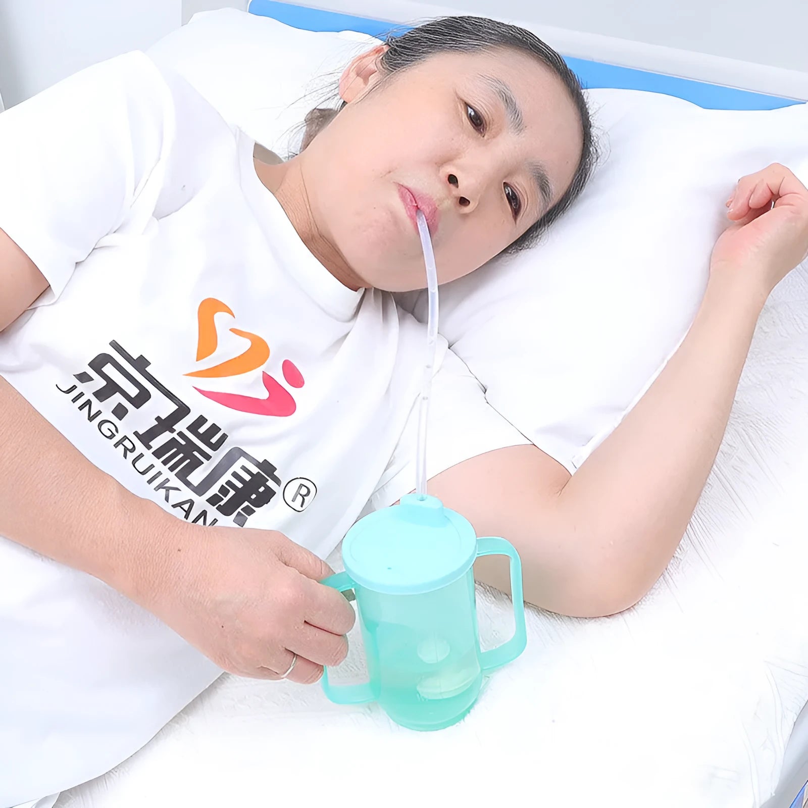 A white PP plastic choke proof drinking cup with a handle, lid, and oblique mouth spout for bedside use.