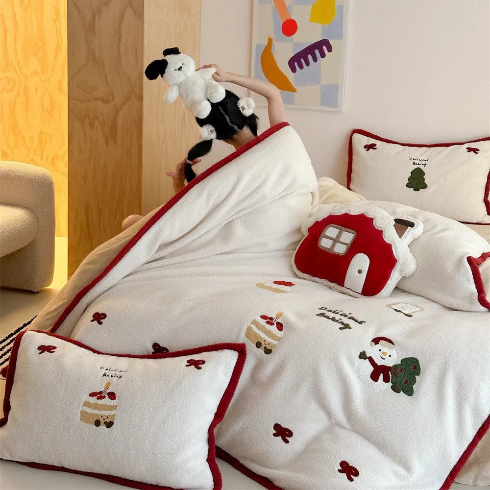 Girl's winter cartoon print bedding four-piece set with bed sheet, duvet cover, and pillowcases on a bed.
