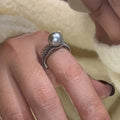 Adjustable open copper ring with geometric shape and black pearl detail on index finger