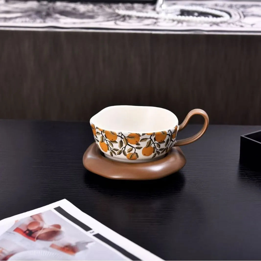 Antique style ceramic coffee cup and saucer set with medieval botanical print in black or orange.