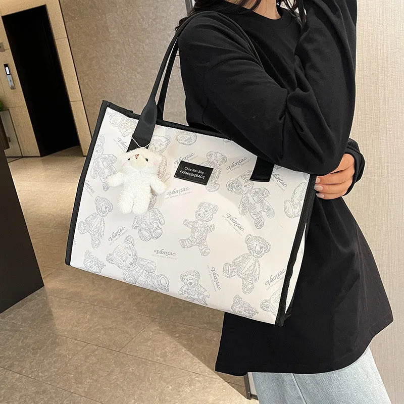 Women's black and white printed canvas tote bag showing rhombus pattern and sandwich pocket.