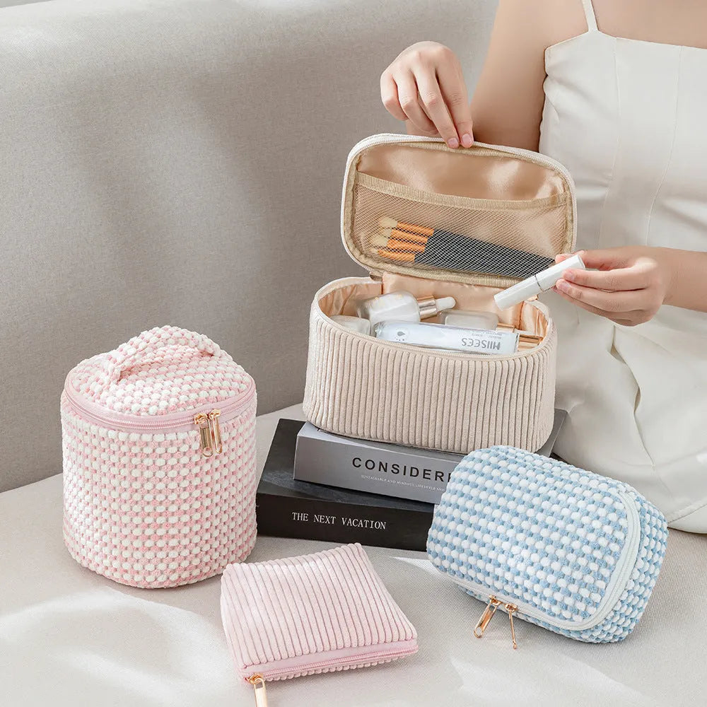 Four cube style makeup bags in different colour patterns including pink, khaki, and dotted designs