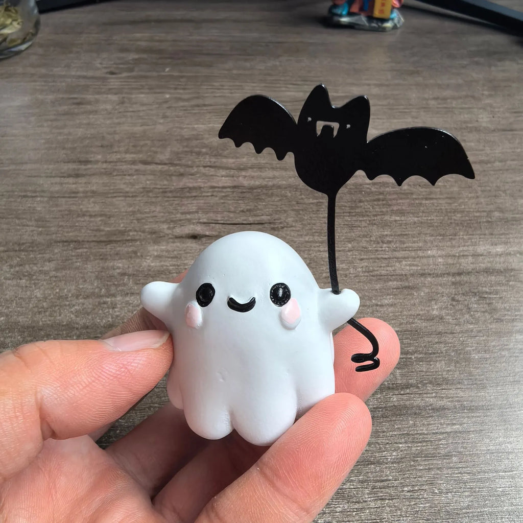 Small resin statue of a ghost walking a dog, a Halloween decoration.