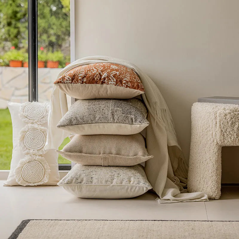 A 45cm square solid-colour cushion with stitched edges on a grey sofa.