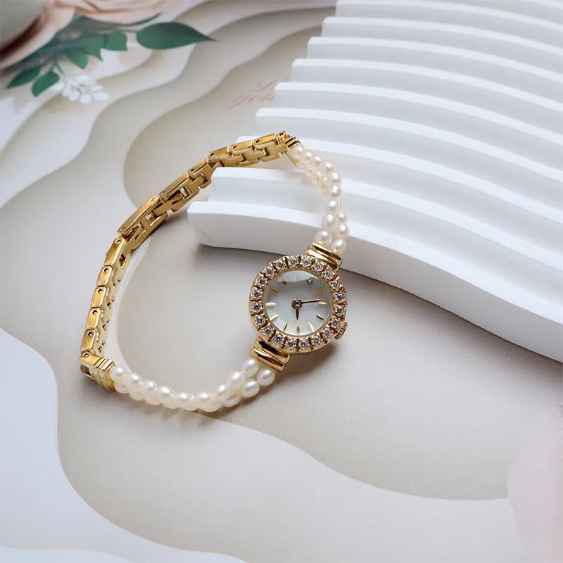 Light gold women's bracelet watch with freshwater pearls, round dial, and stainless steel strap