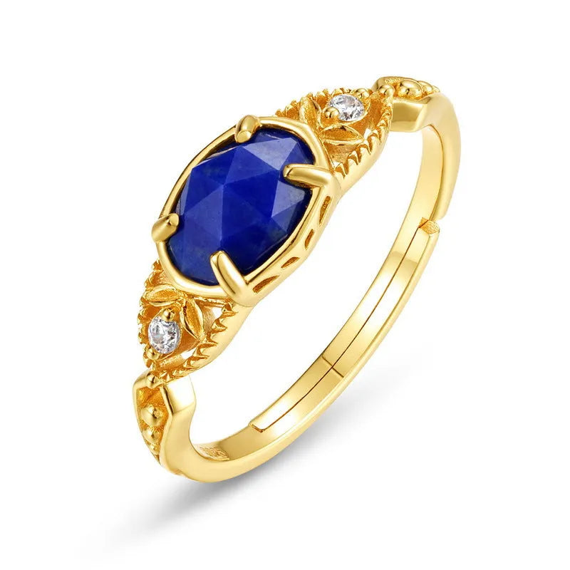 Silver geometric elliptical ring with a blue lapis lazuli stone and round decorative element.