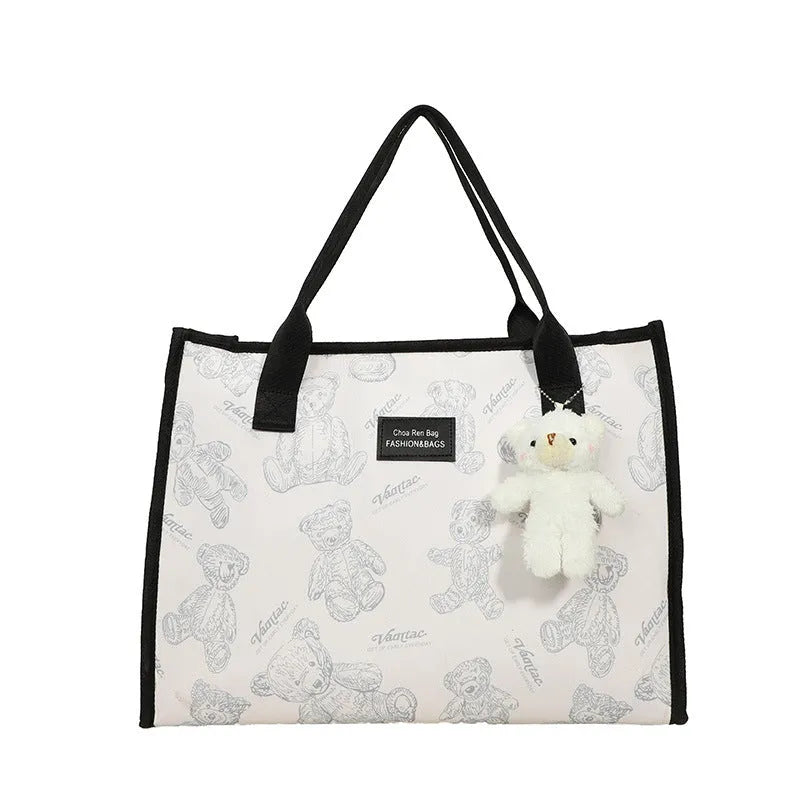 Women's black and white printed canvas tote bag showing rhombus pattern and sandwich pocket.