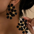 Retro flower-shaped iron earrings for women in black and white colour options.