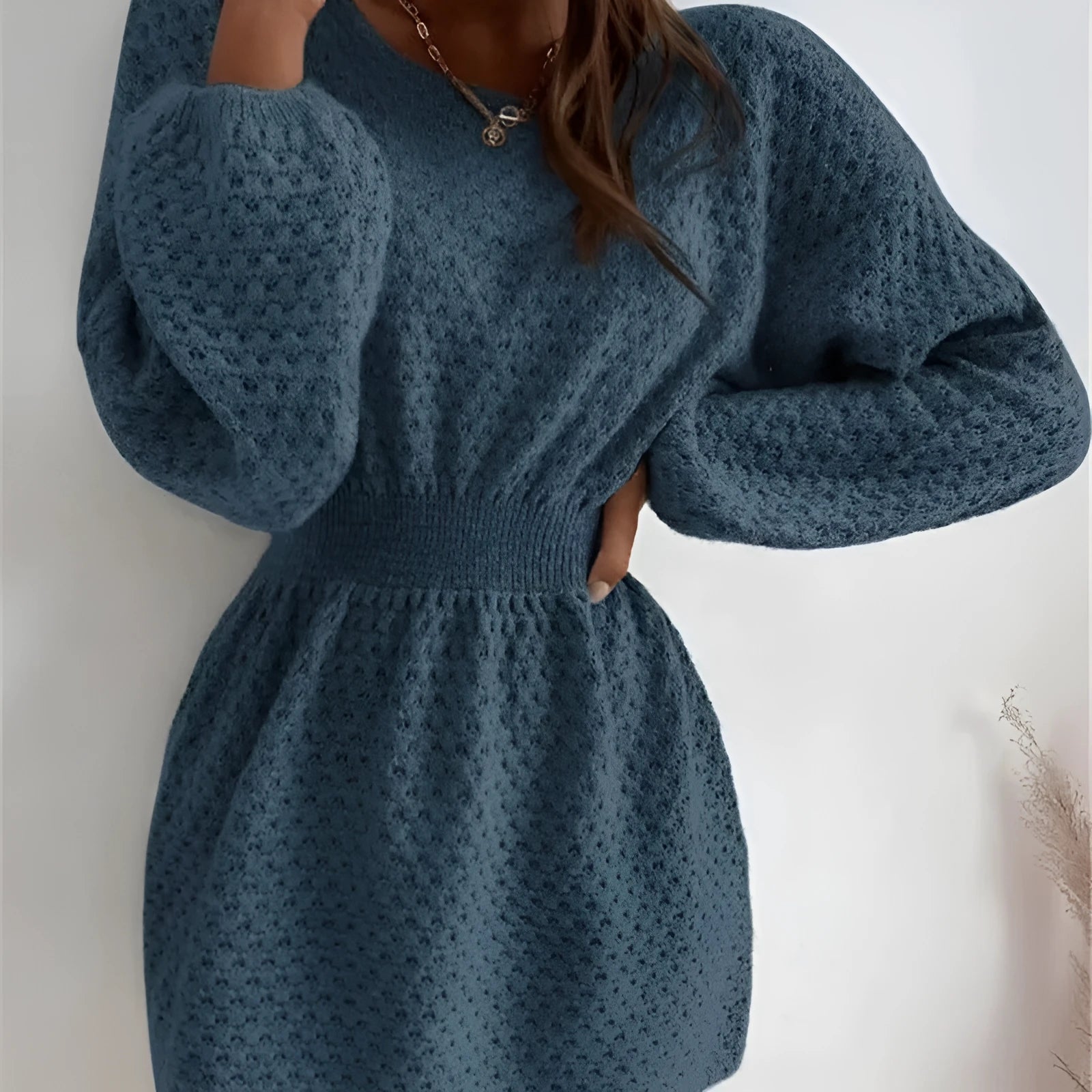 Blue women's knitted dress with hand-crocheted flowers, round neck, and fitted waist.