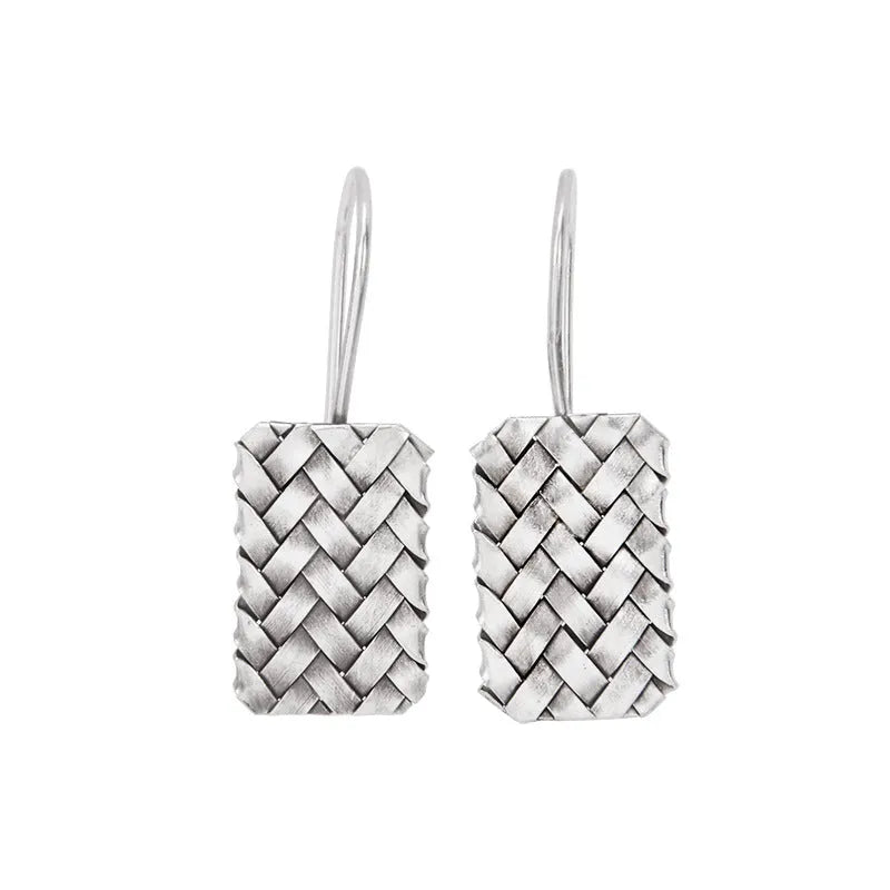 Silver geometric earrings with a woven diamond plaid pattern on a white background.
