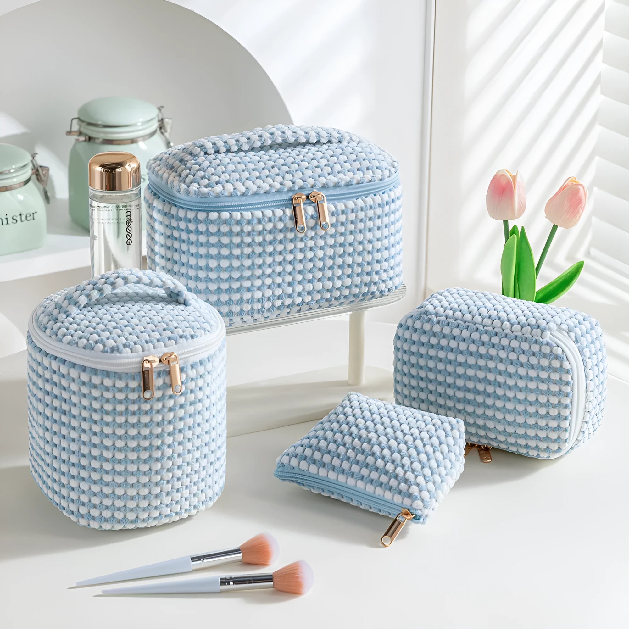 Four cube style makeup bags in different colour patterns including pink, khaki, and dotted designs
