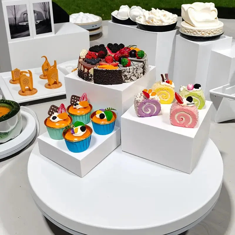 White plastic modular cube set assembled as a tiered desktop dessert display stand.