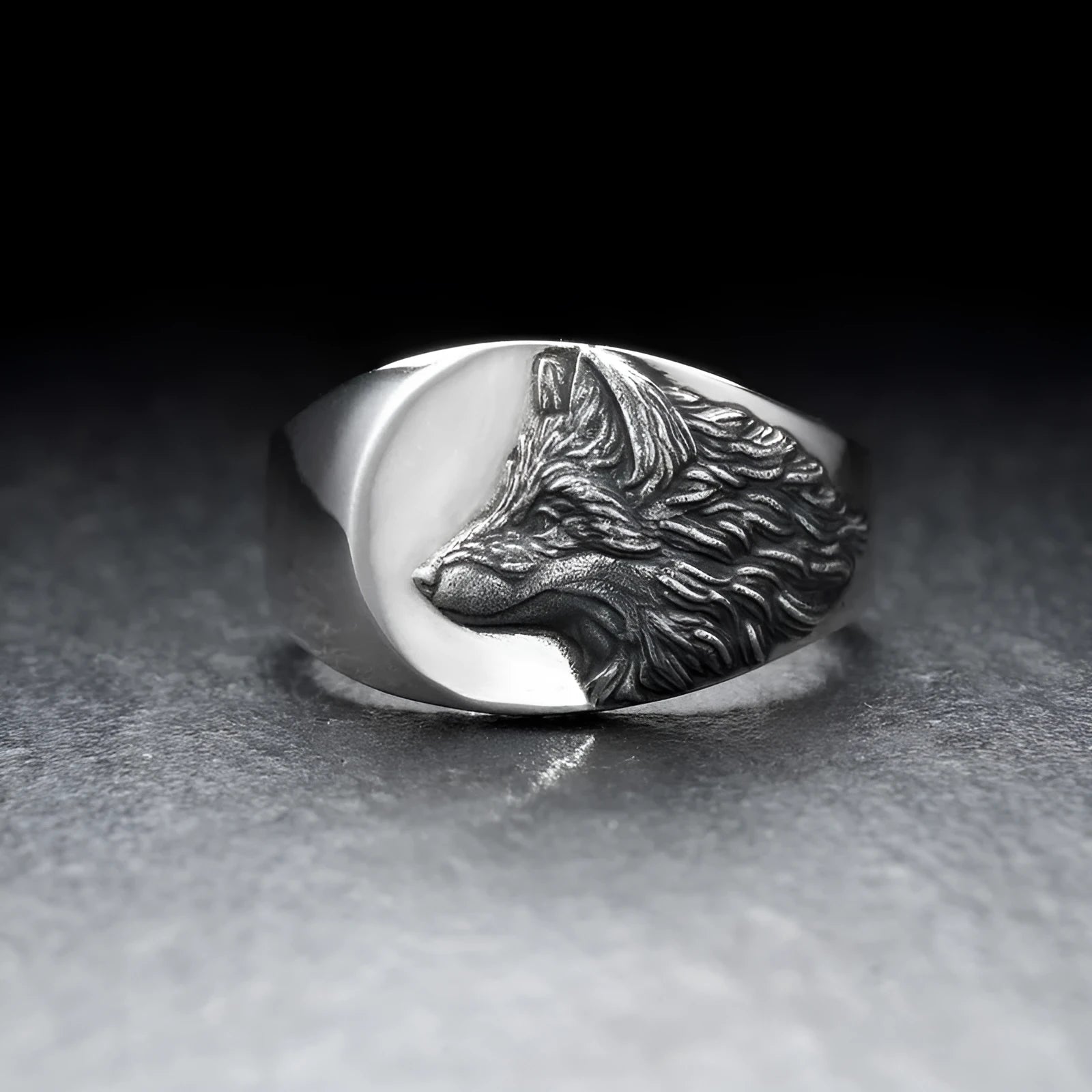 Silver geometric wolf head ring for men on a grey background.