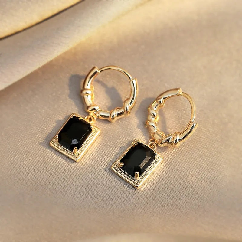 A pair of square geometric copper earrings with a black zircon in a French court retro setting.